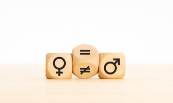 Holzklotz, der ein Ungleichheitszeichen in ein Gleichheitszeichen zwischen Symbolen für Männer und Frauen verwandelt