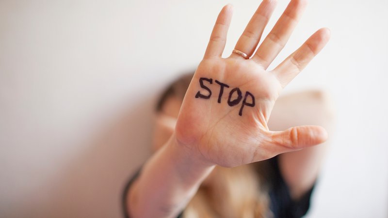 Hand in Abwehrhaltung mit Aufschrift STOP