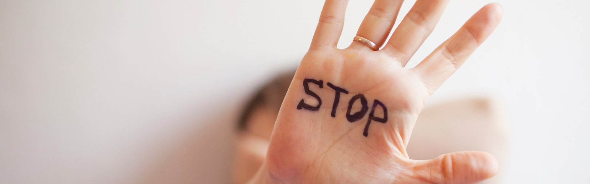 Hand in Abwehrhaltung mit Aufschrift STOP