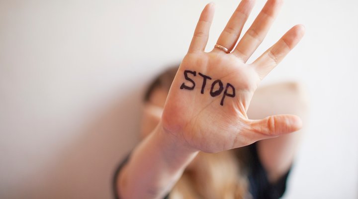 Hand in Abwehrhaltung mit Aufschrift STOP