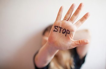 Hand in Abwehrhaltung mit Aufschrift STOP