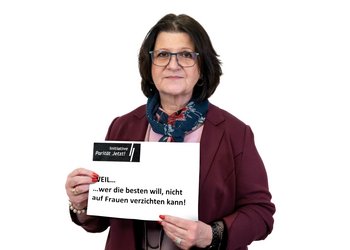 Frau hält Schild PARITÄT JETZT